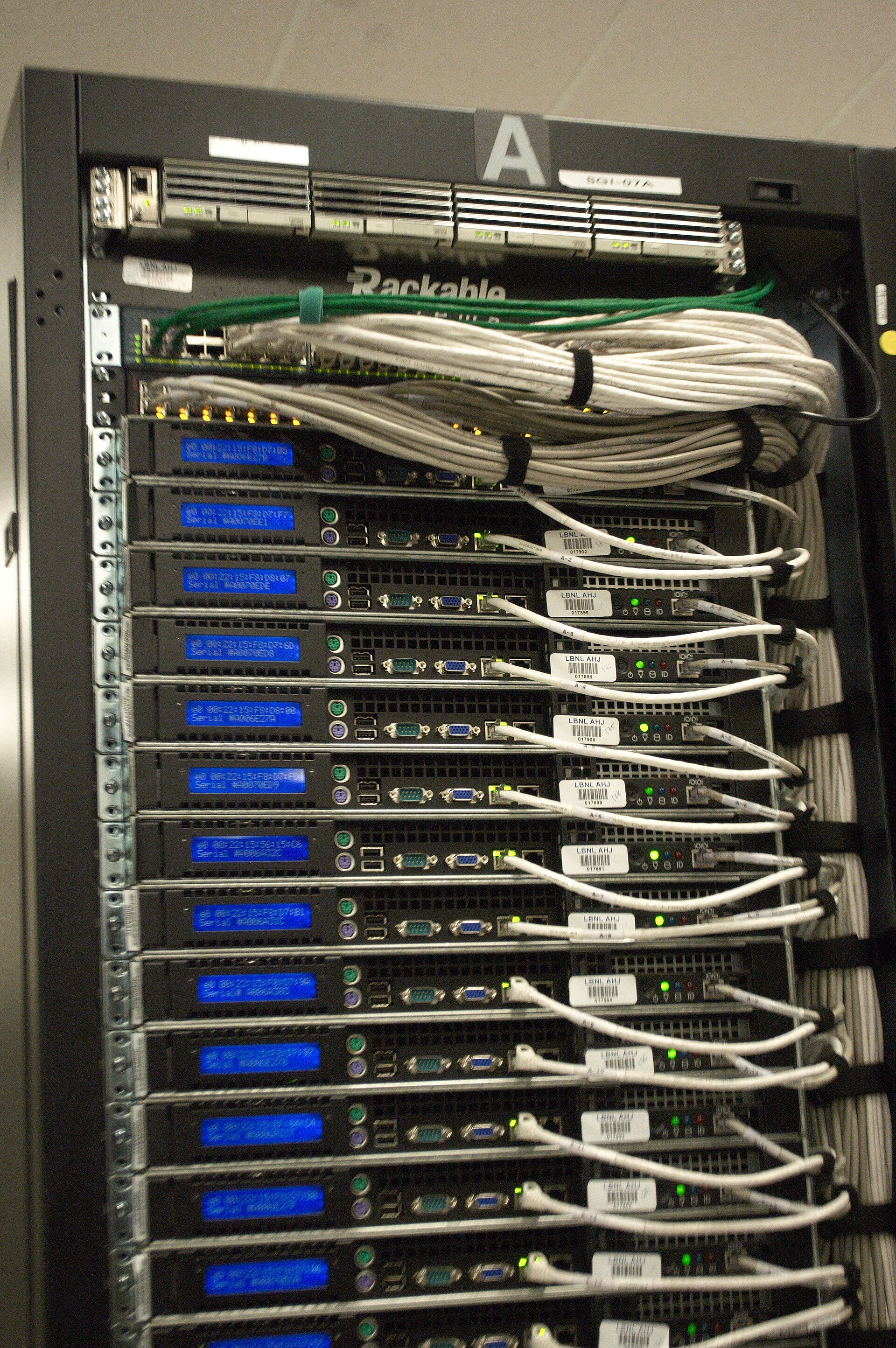 Back of a server rack in a data center with many cables